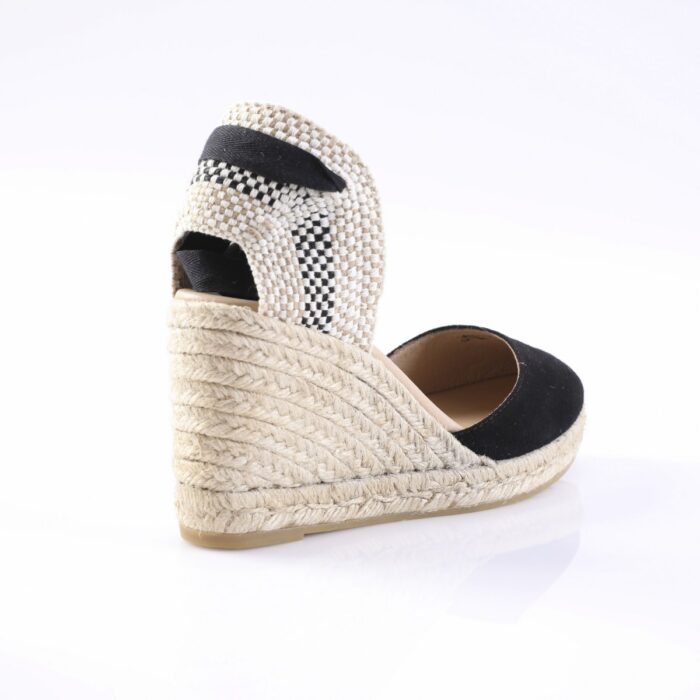 Espadrille wedge sandal with braided jute sole and black fabric straps, viewed from the back.