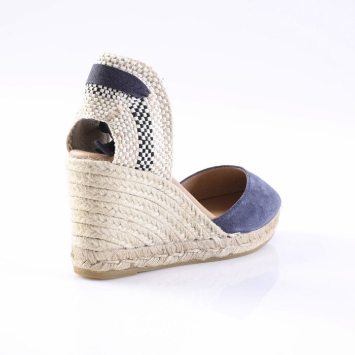 Navy blue suede espadrille wedge sandal with a braided rope heel and woven back strap. Alternative: Wedge sandal with navy toe, braided rope sole, and checkered back strap.