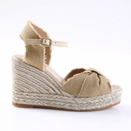 Beige espadrille wedge sandal with an ankle strap and frayed fabric edges on a braided rope sole.