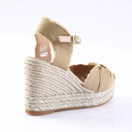 Beige woven-strap espadrille wedge sandal with ankle buckle.