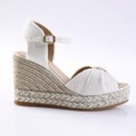 White canvas wedge sandal with ankle strap and braided jute sole on a light background, side view.
