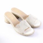 Beige wedge espadrille sandals with braided jute sole and decorative wavy strap across the top, open-toe design