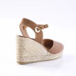 Brown leather wedge espadrille sandal with an ankle strap and buckle, viewed from the side showing the braided jute wedge heel and beige sole.