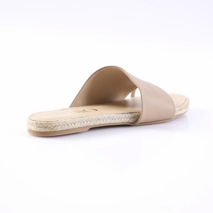 Beige slide sandal with a single wide strap and braided espadrille sole on a white background, viewed from the side.