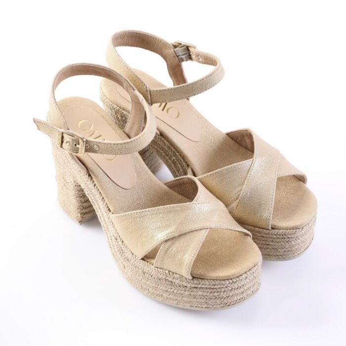 Beige gold wedge espadrille sandals with ankle straps and woven jute heels on a white background
