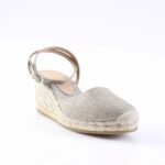 Silver glitter espadrille wedge sandal with ankle strap and woven jute sole on a white background.