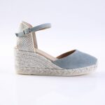 Blue suede espadrille wedge sandal with braided jute sole, open toe, and ankle strap with a buckle.