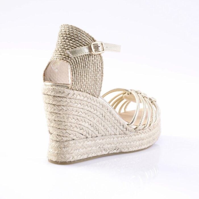 Gold wedge espadrille sandal with braided jute sole and thin ankle strap, shown from the back-left side