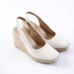 White slingback wedge espadrille sandals with braided jute platform and open toe, shown from a side angle on a white background.