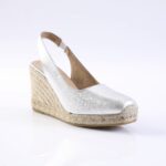 Silver metallic wedge sandal with ankle strap and braided rope espadrille sole.