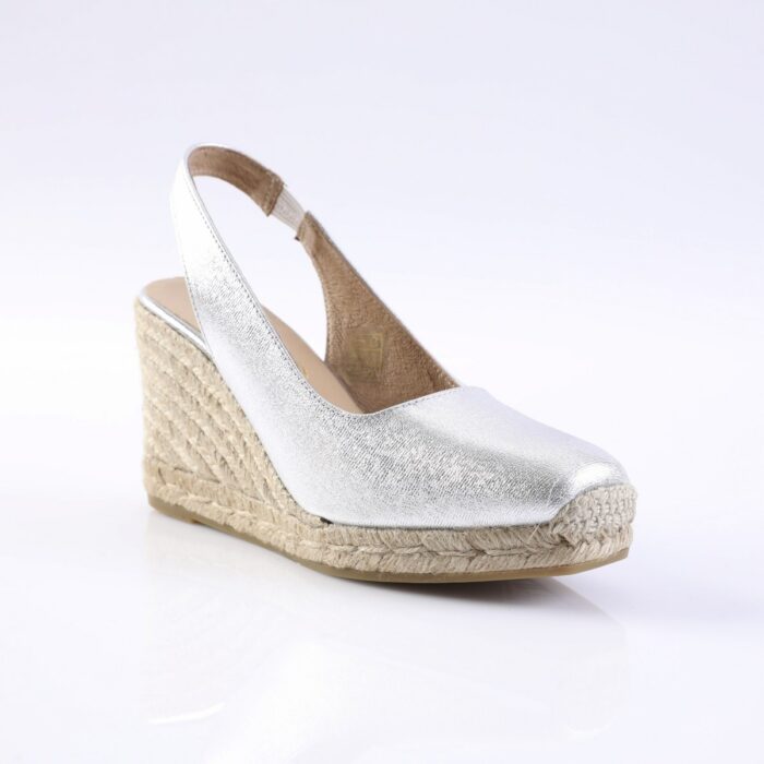 Silver metallic wedge sandal with ankle strap and braided rope espadrille sole.
