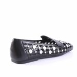 Black flat shoe with a cut-out lattice design and silver studs along the sides, low heel visible at the back.