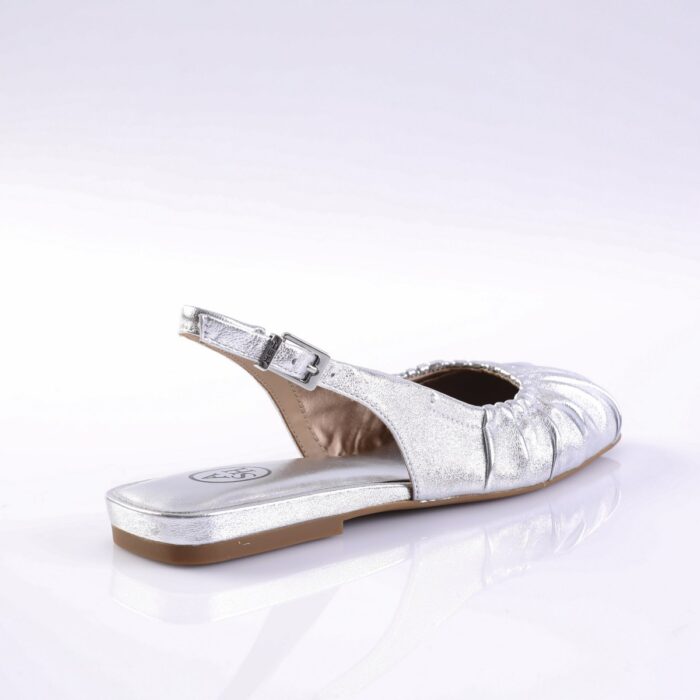 Silver metallic slingback sandal with an adjustable buckle and a flat beige sole, shown from the side.