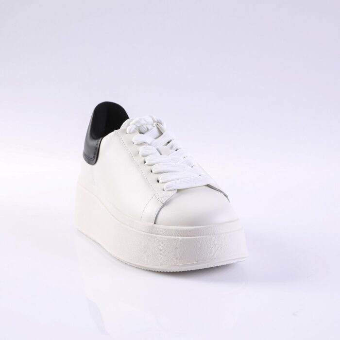 White platform sneaker with white laces and a black heel patch, shown from a front-left angle.