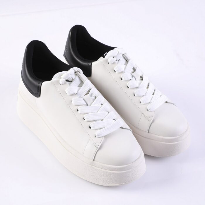 White platform sneakers with black padded heel collar and white laces on a white background.