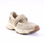 Beige sneaker with Velcro strap and mesh panels on a white background, showing a rugged sole edge.
