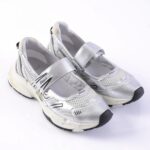 Silver athletic sneakers with mesh panels and two Velcro straps, chunky white sole, and black toe caps (brand ASH visible).