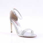 Silver strappy high-heeled sandal with an ankle strap and open toe, shown from a side angle for a formal shoe context.