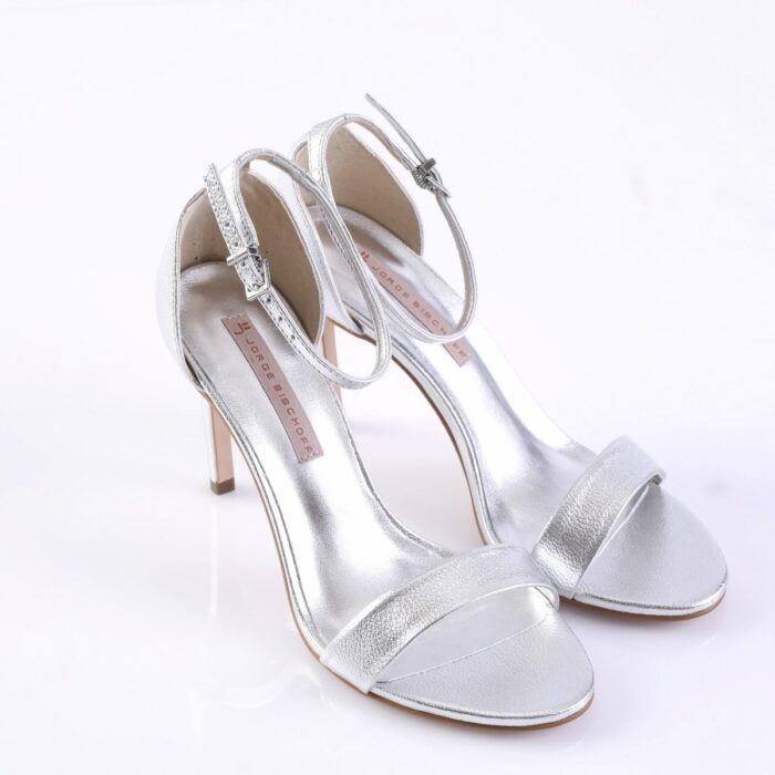 Silver high-heeled sandals with delicate ankle straps and a rhinestone-buckle detail, open-toe style