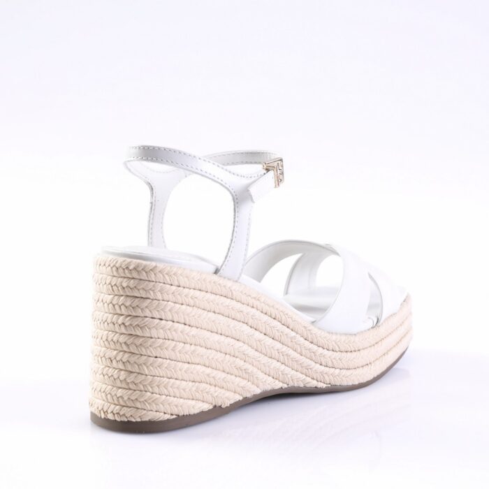 White strappy wedge sandal with a braided rope platform and ankle strap viewed from the side, showcasing the espadrille-style sole.