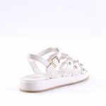 White leather sandal with multiple straps, gold buckle, and round metal grommets on a white platform sole with a light brown outsole