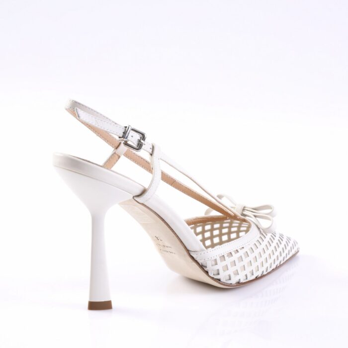 White lattice-cutout sandal with ankle strap and bow, shown from the side on a white background and slim heel.