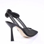 Black mesh stiletto heel sandal with an ankle bow detail on a white background