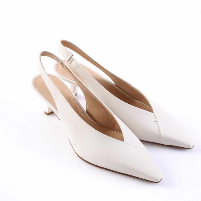 White slingback pointed-toe pumps with low block heel on a white background, showing inner tan lining and stitching detail