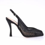 Black mesh pump with a slender ankle strap and buckle, pointed toe, and high stiletto heel—women's dress shoe.