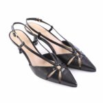Black pointed-toe slingback high heels with thin straps and gold buckle detail, positioned on a white background for product photography