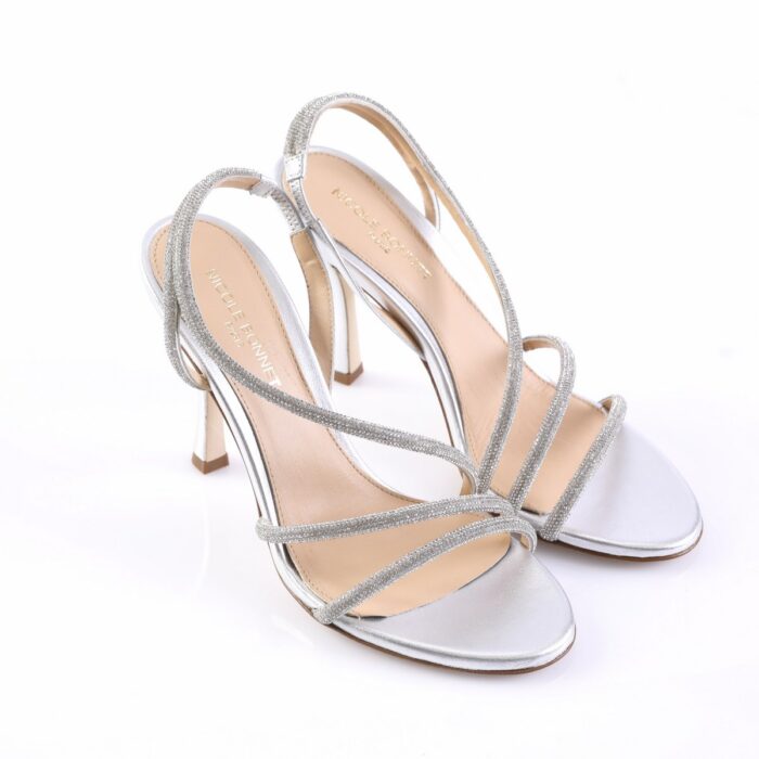 Silver glitter strappy high-heeled sandals with thin crossing straps and ankle strap.