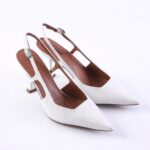 White pointed-toe slingback heels with slim ankle straps and brown inner lining on a white background.