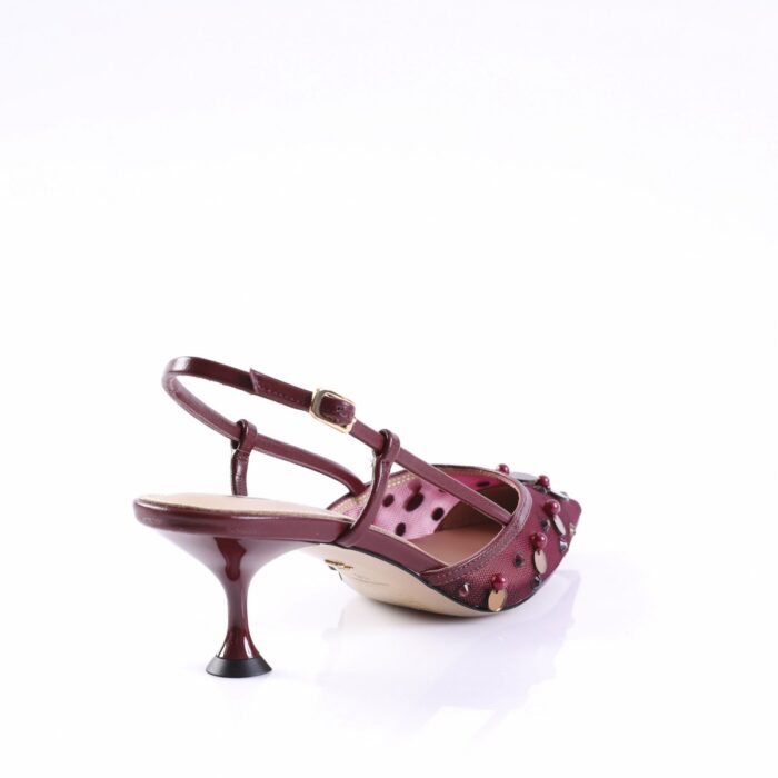 Maroon women's heeled sandal with an ankle strap and studded embellishments, photographed from the side.Paraphrase: Burgundy strappy pump with decorative beads and buckle.