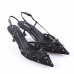 Black pointed-toe slingback heels with decorative studs and beads on a white background
