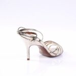 Back view of a metallic silver snakeskin-embossed high-heeled sandal with thin straps.