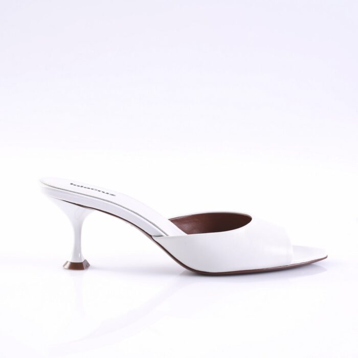 White open-toe mule sandal with a slender, curved kitten heel on a glossy white surface viewed from the side.