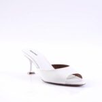 White open-toe mule with a curved slender heel on a glossy white surface, showcasing a minimalist high-heeled sandal