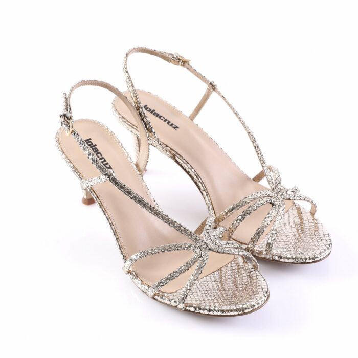 Gold glittery strappy high-heeled sandals with open toes on a white background.