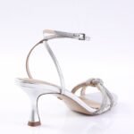 Silver high-heeled sandal with ankle strap and braided rhinestone front strap, photographed from the side.