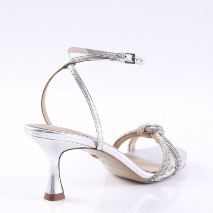 Silver high-heeled sandal with ankle strap and braided rhinestone front strap, photographed from the side.