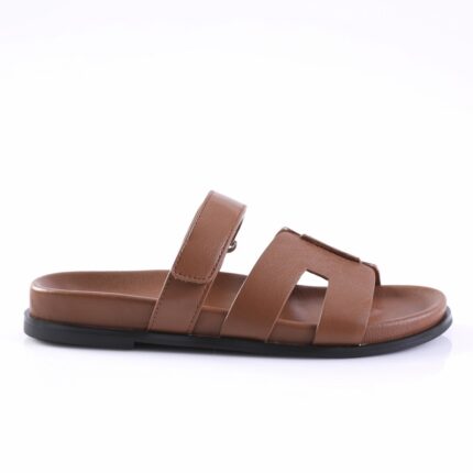 Brown leather slide sandal with two wide straps and a black sole, shown from side profile.