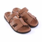 Brown leather sandals with two wide straps over the foot and a black rubber sole.