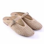 Beige perforated suede Mary Jane shoes with a buckle strap on a white background