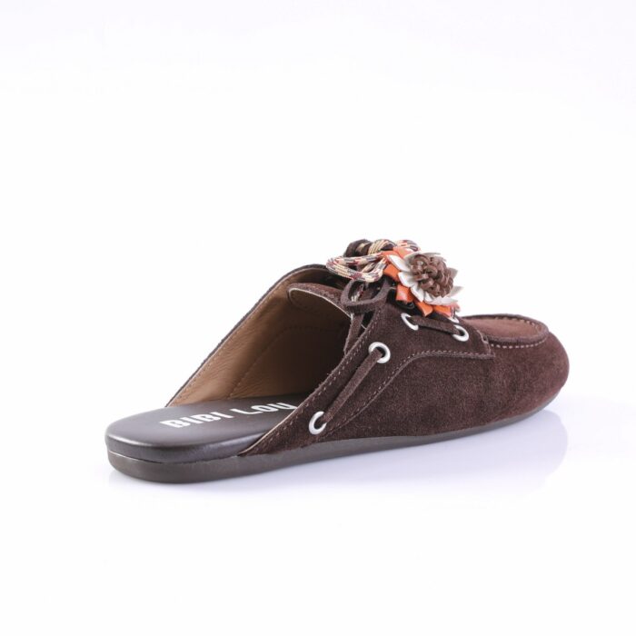 Brown suede mule/slip-on sandal with a braided fabric flower on the vamp against a white background.