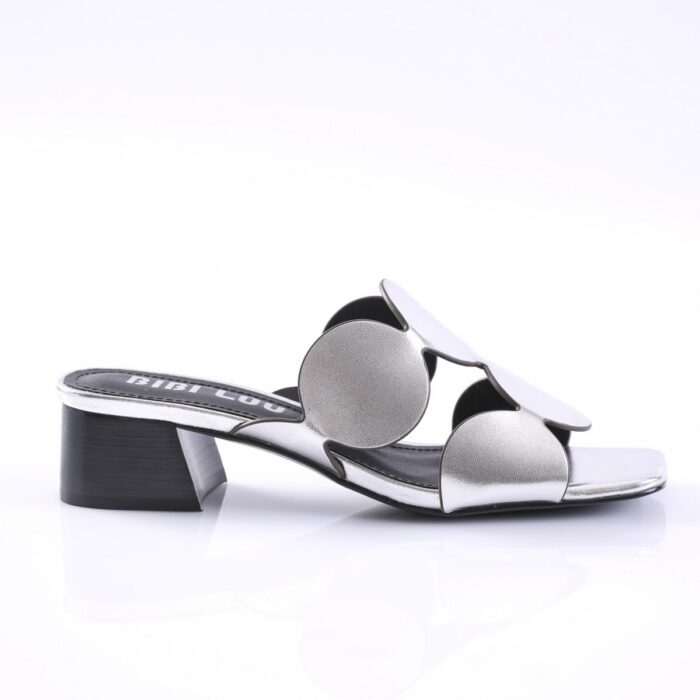 Silver metallic slide sandal with two large circular cutouts along the strap and a low block heel, open-toe design.
