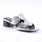 Open-toe silver metallic slide sandal with a large flower-shaped strap and a short block heel.