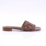 Brown leather slide sandal with two braided straps and decorative perforated scalloped edges, low block heel, side view