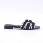 Navy blue crocheted slide sandal with white trim and a low heel, shown from the side.
