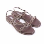 Brown flat sandals with rhinestone-encrusted, interwoven chain straps and studded edge along the sole, on white background.