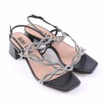 Black open-toe sandals with a chunky low heel and silver rhinestone-embellished interwoven straps across the top and around the ankle buckle